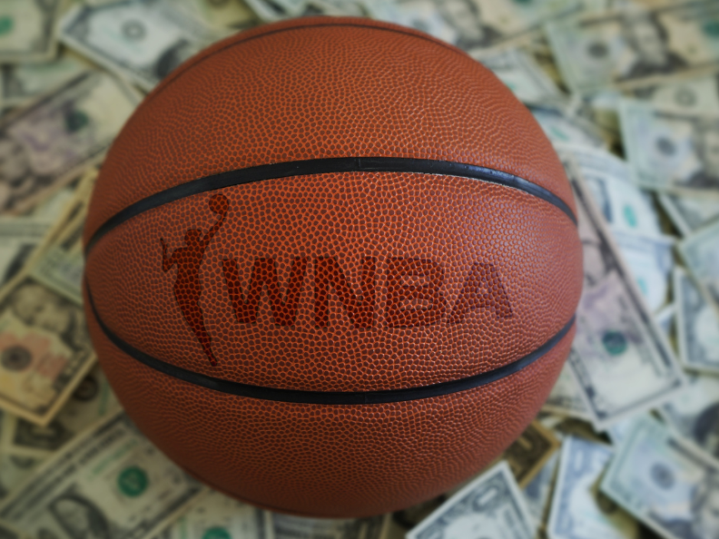 image of basketball with WNBA logo, surrounded by cash