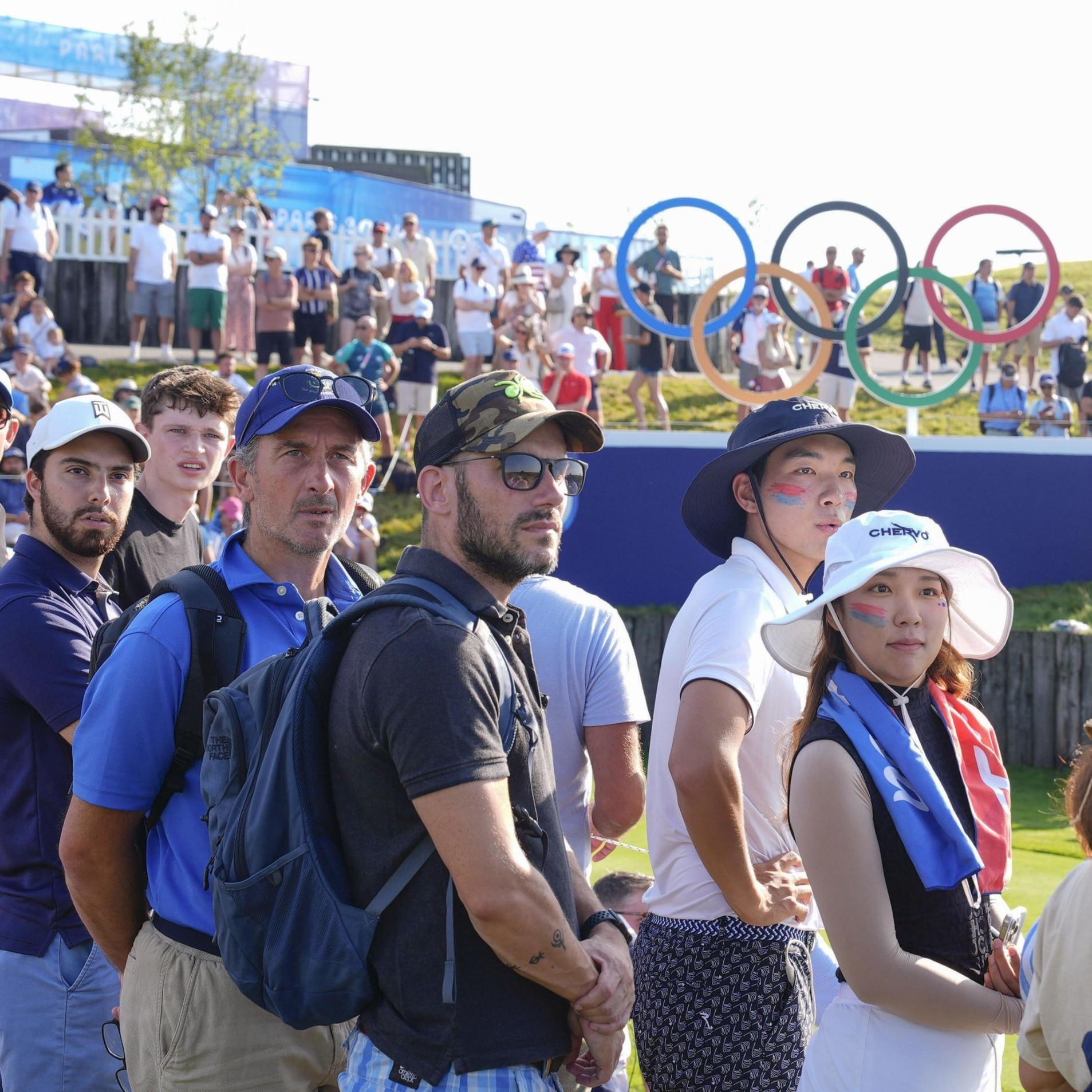 Fans following ball as tee shit is taken at Olympics