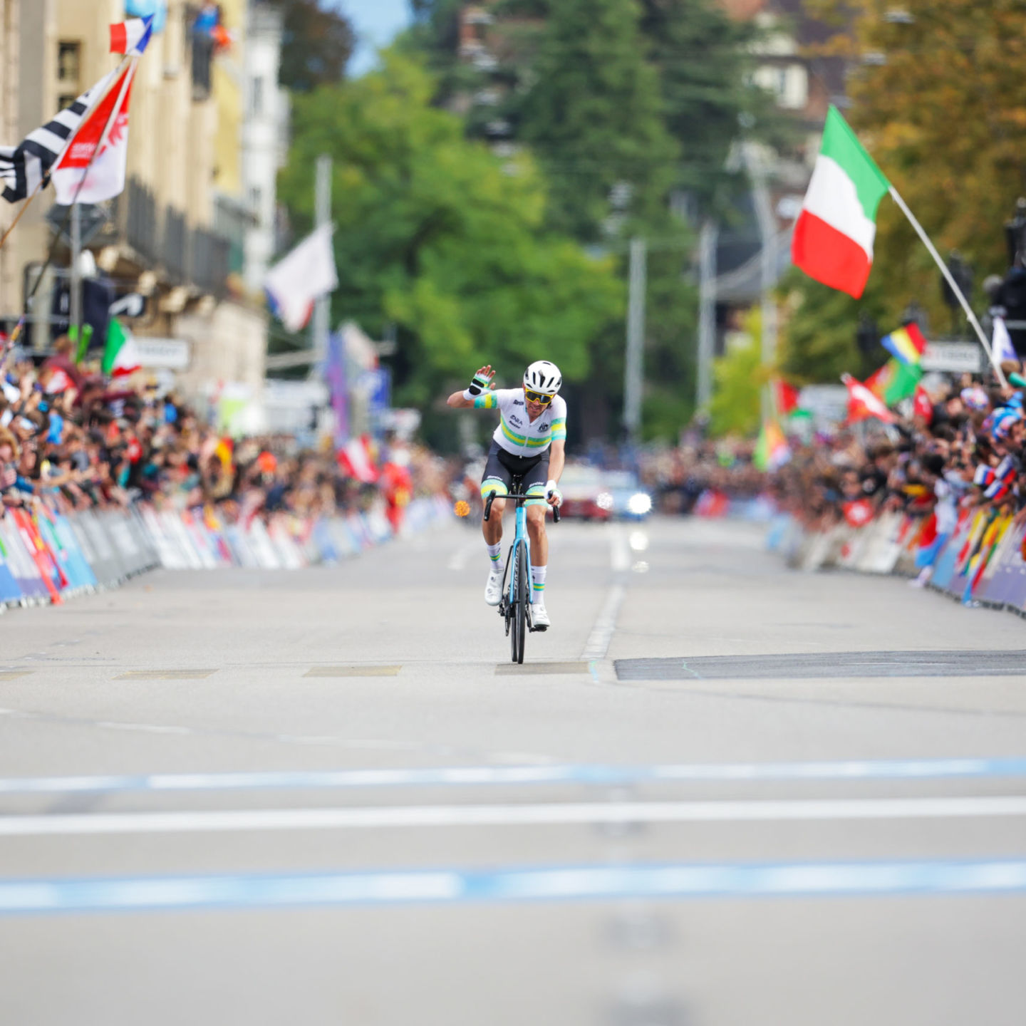 Male cyclists with fist in the air as he heads towards the finish line for the win