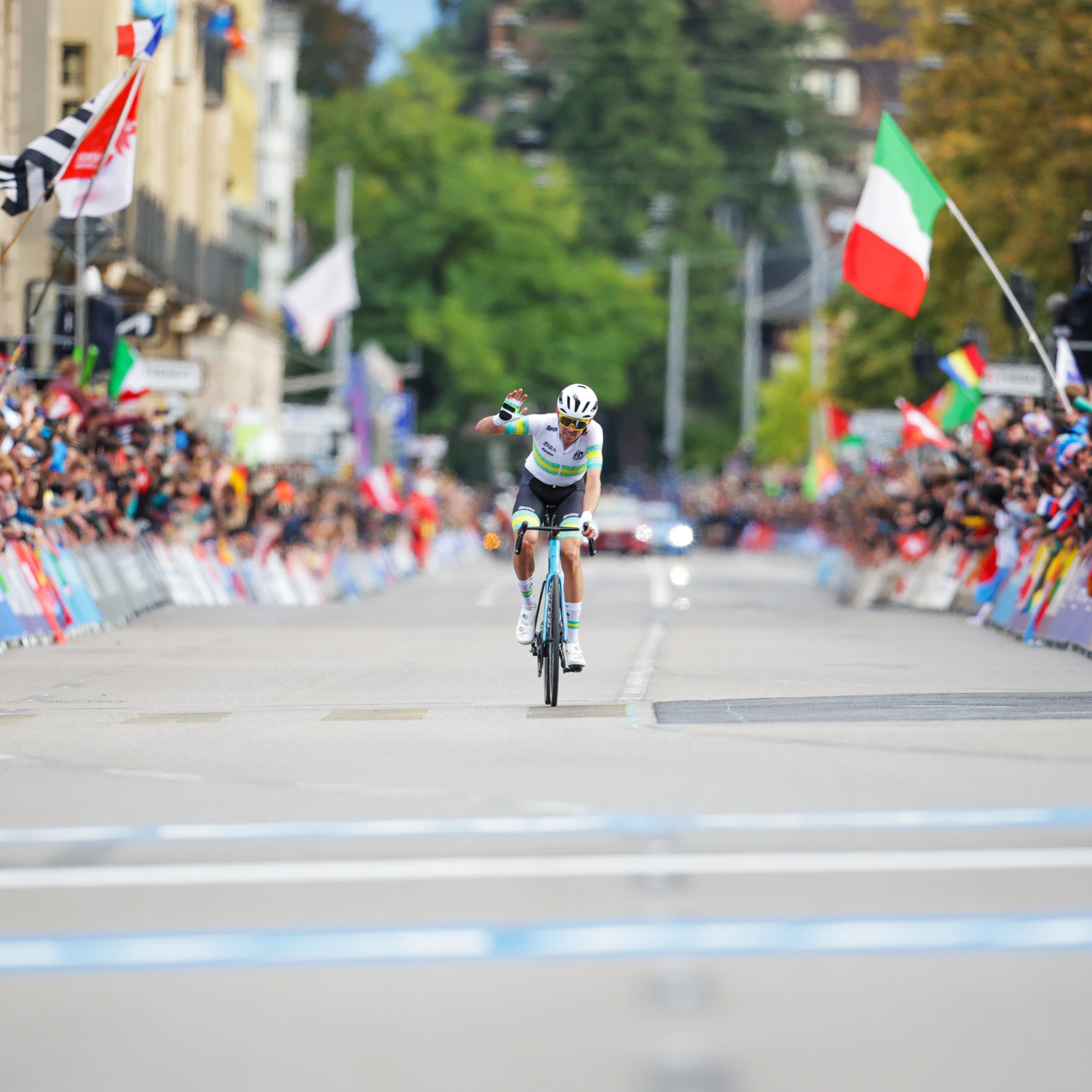Male cyclists with fist in the air as he heads towards the finish line for the win