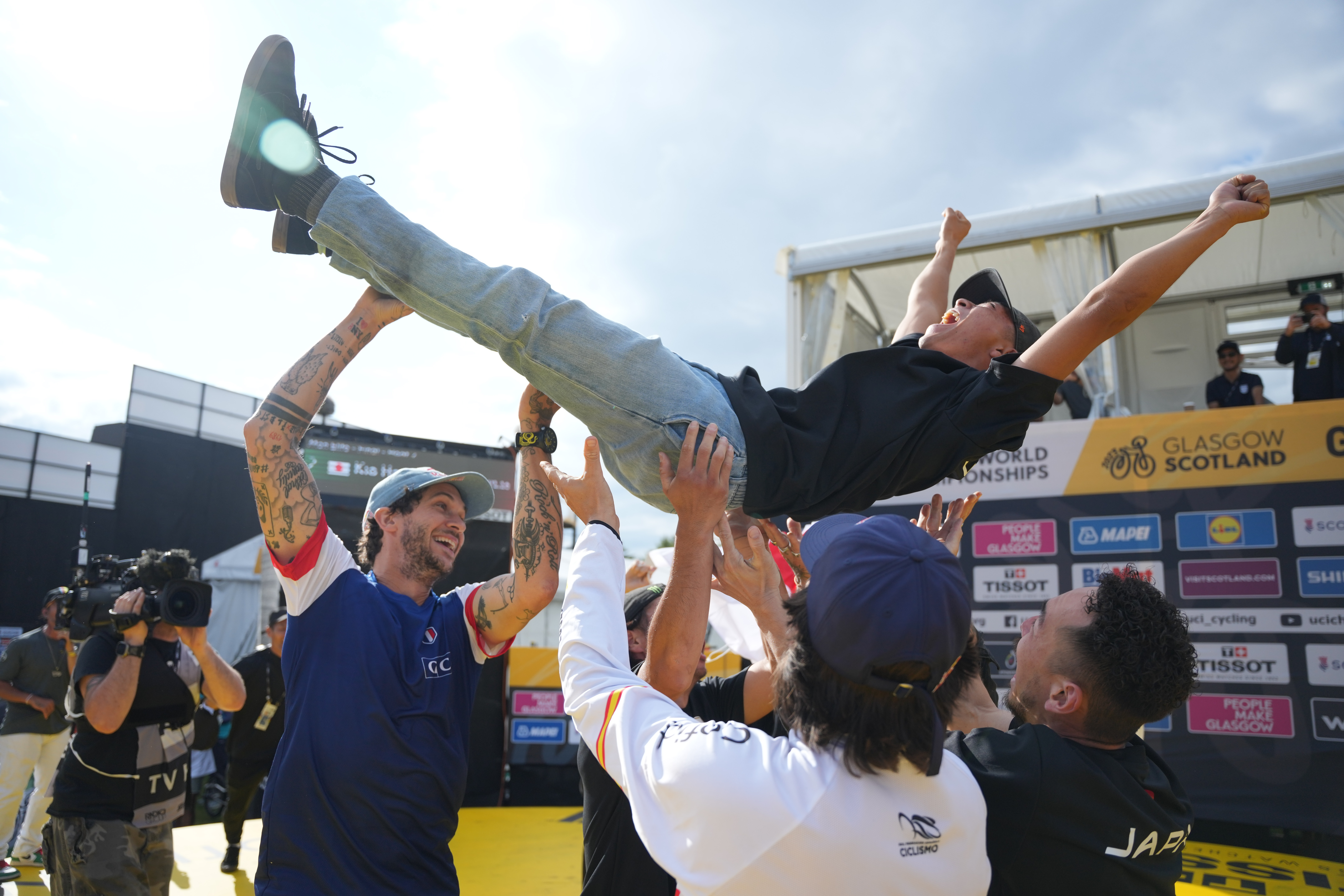 BMX athlete being hoisted up by fellow riders after winning competition