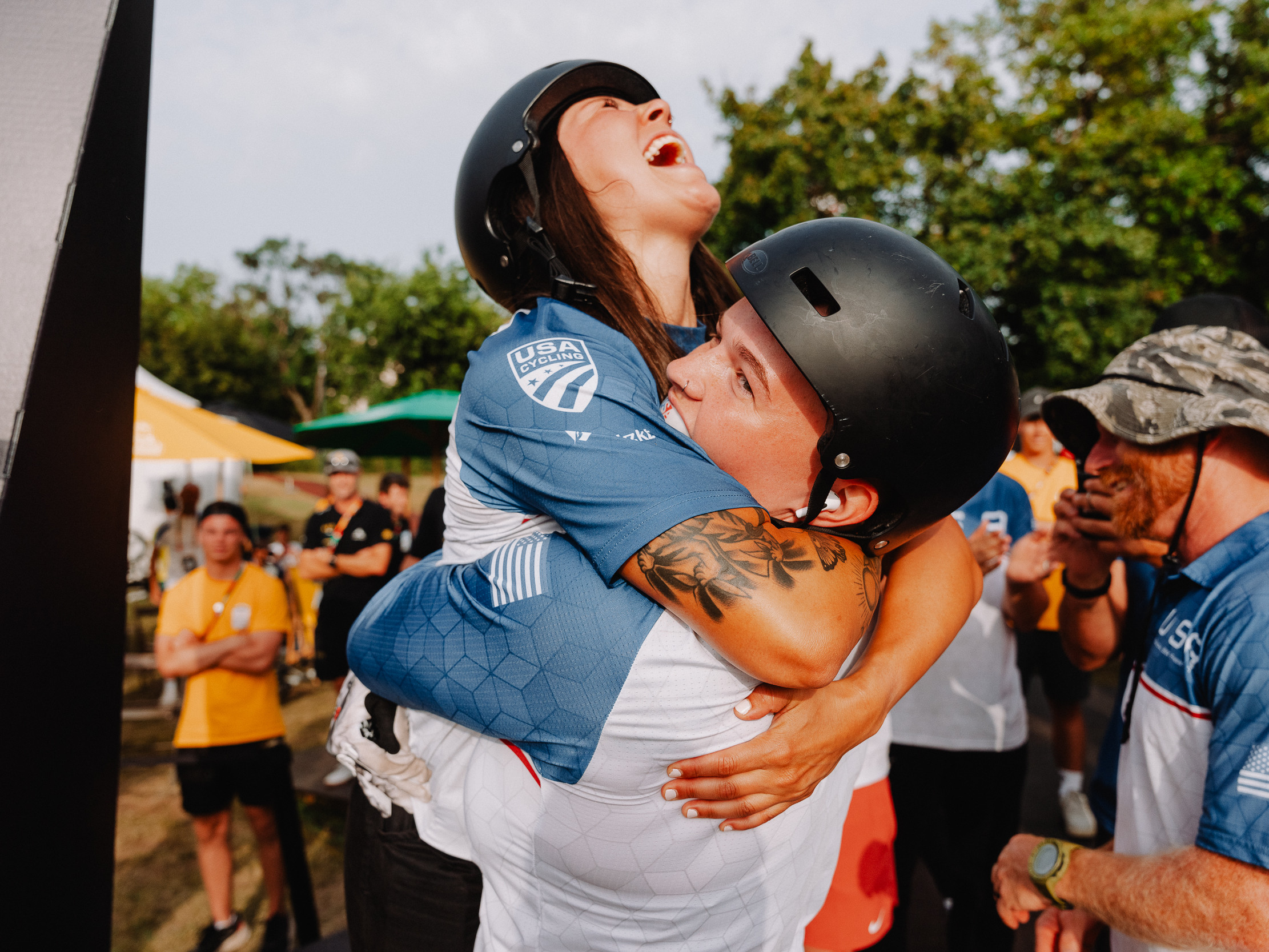 Two UCI BMX riders hugging after winning a medal.