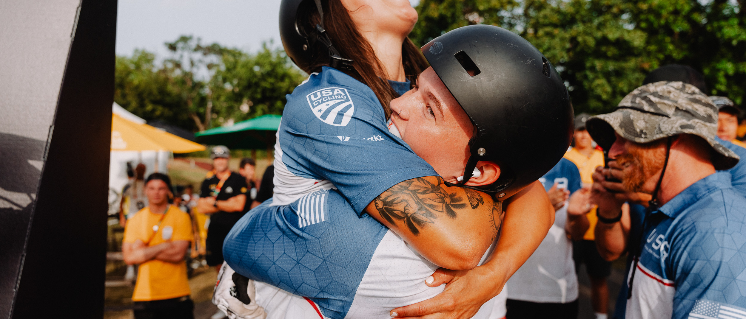 Two UCI BMX riders hugging after winning a medal.