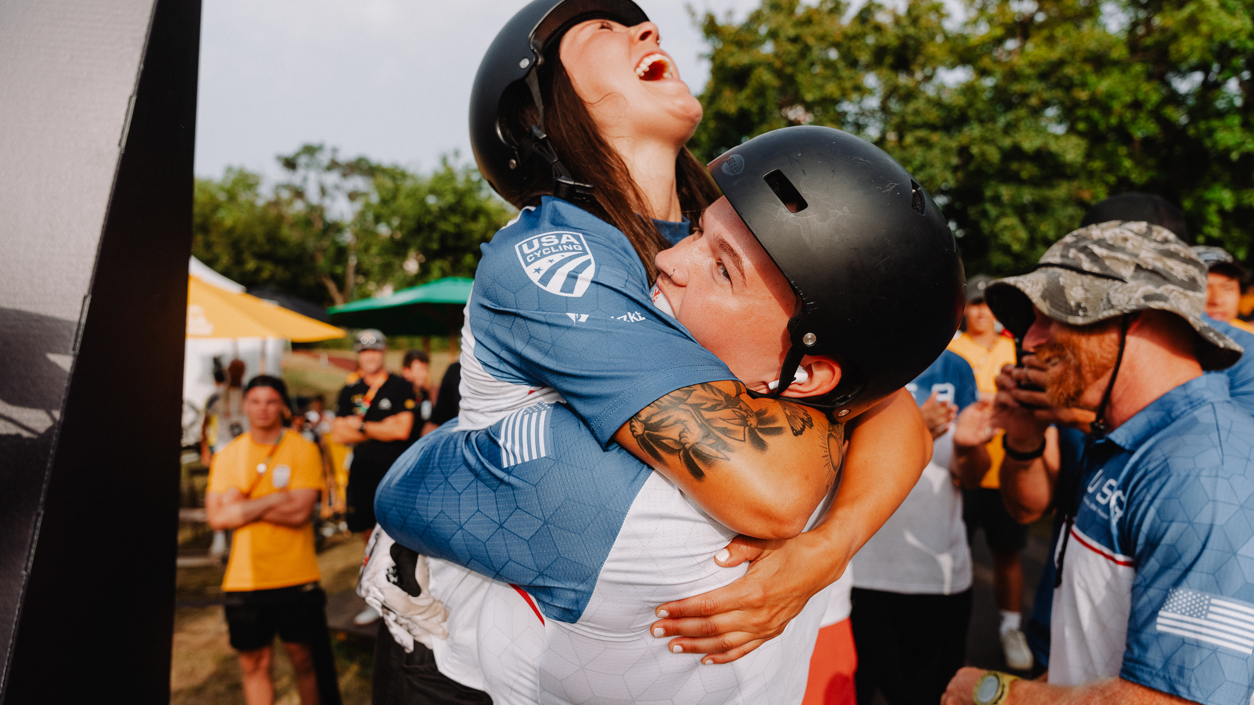 Two UCI BMX riders hugging after winning a medal.
