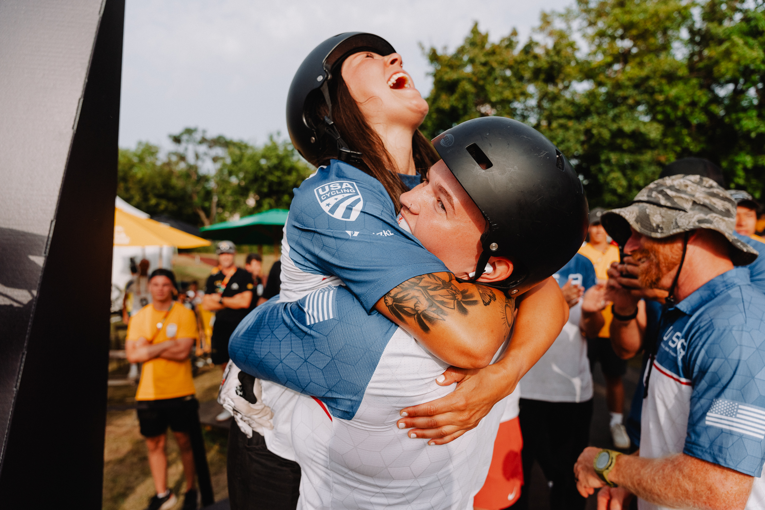 Two UCI BMX riders hugging after winning a medal.