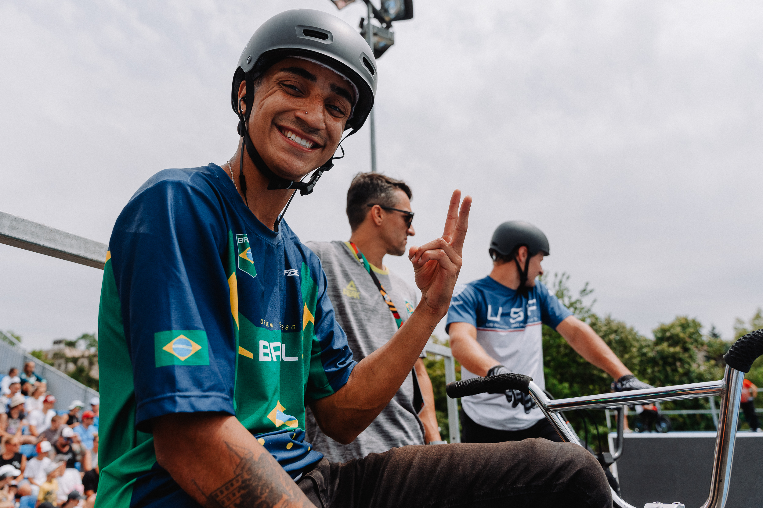 BMX riders posing for camera on top of ramp while they wait for their run