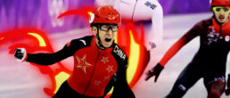 Chinese speed skater celebrating victory as he crosses the line