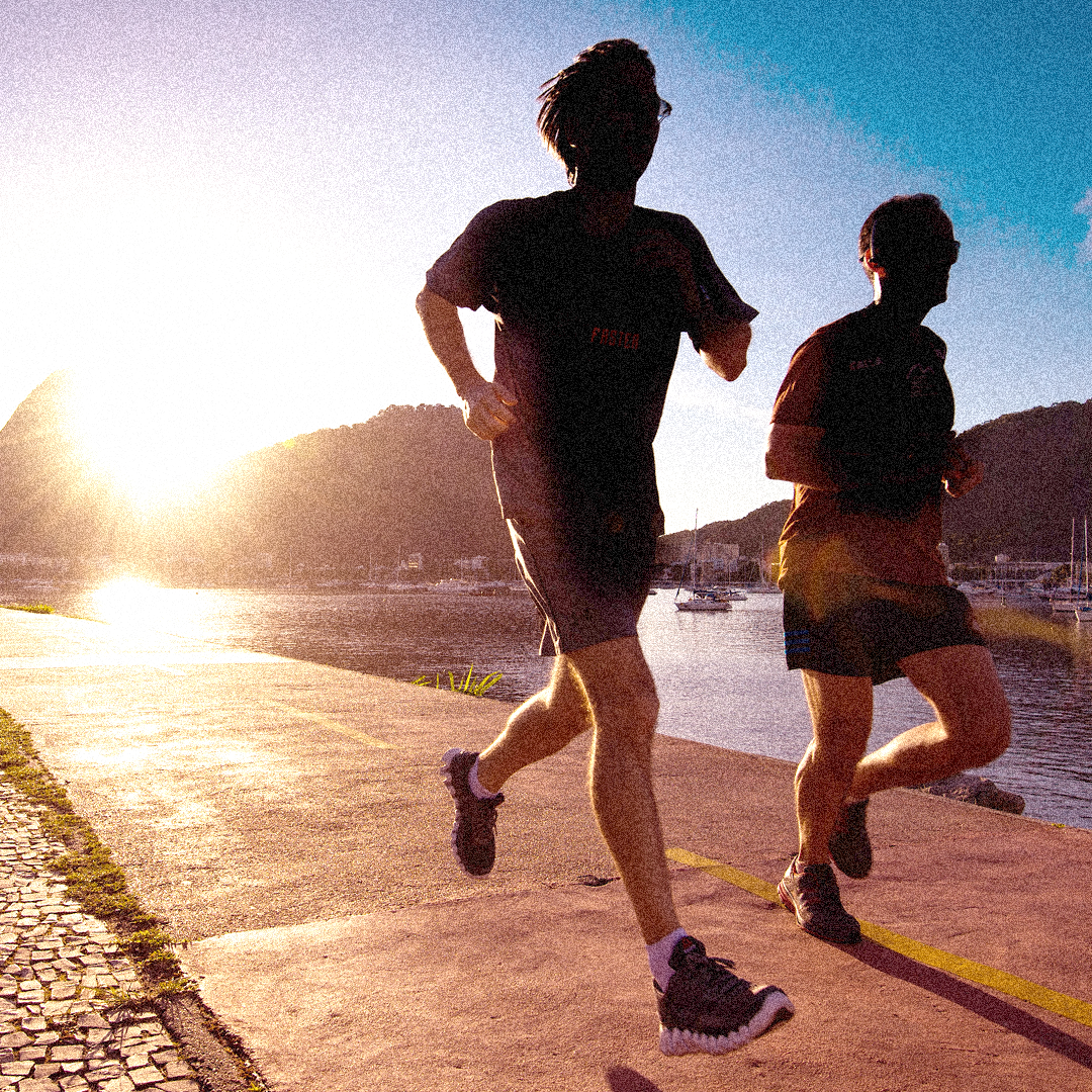 SportOnSocial Global Running Culture 2025 - Silhouette of two men running with the sun setting behind