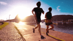 SportOnSocial Global Running Culture 2025 - Silhouette of two men running with the sun setting behind