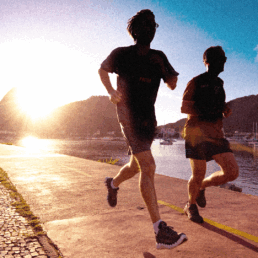 SportOnSocial Global Running Culture 2025 - Silhouette of two men running with the sun setting behind