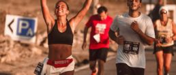 SOS Running: Two people running a race, one celebrating with her arms in the air