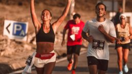 SOS Running: Two people running a race, one celebrating with her arms in the air