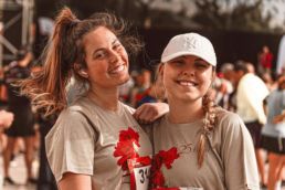 Two friends smiling at a running event - - SportOnSocial Global Running Culture 2025