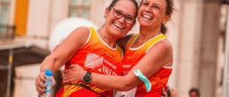 Two women hugging after completing a running race - SportOnSocial Global Running Cultures 2025