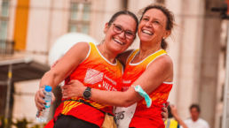 Two women hugging after completing a running race - SportOnSocial Global Running Cultures 2025