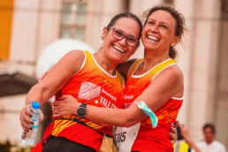 Two women hugging after completing a running race - SportOnSocial Global Running Cultures 2025