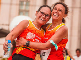 Two women hugging after completing a running race - SportOnSocial Global Running Cultures 2025