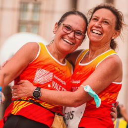 Two women hugging after completing a running race - SportOnSocial Global Running Cultures 2025