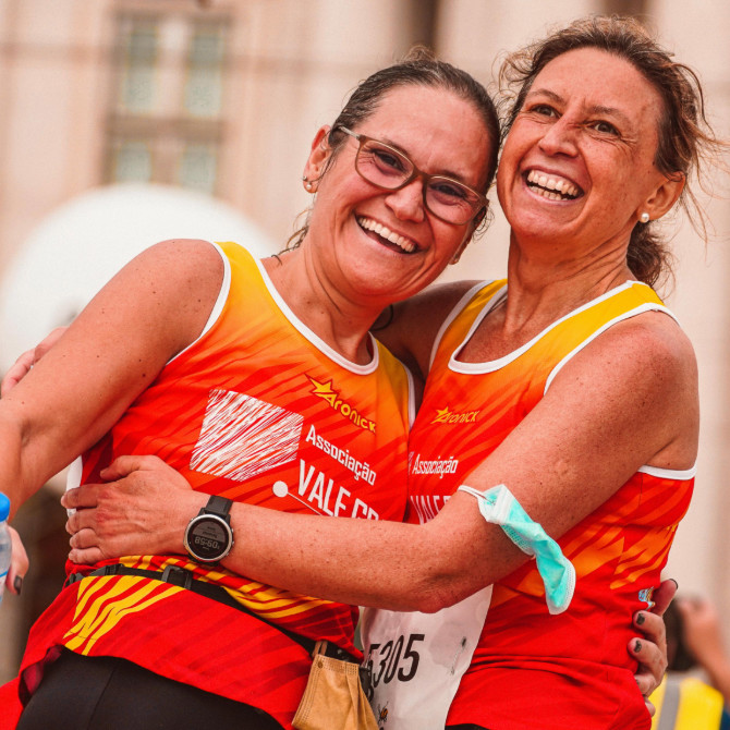 Two women hugging after completing a running race - SportOnSocial Global Running Cultures 2025