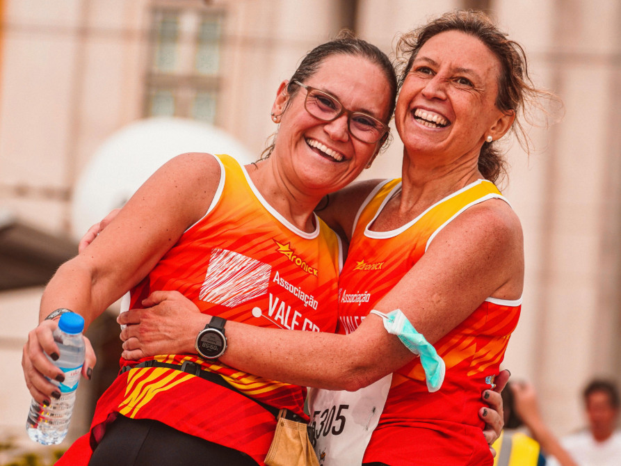 Two women hugging after completing a running race - SportOnSocial Global Running Cultures 2025